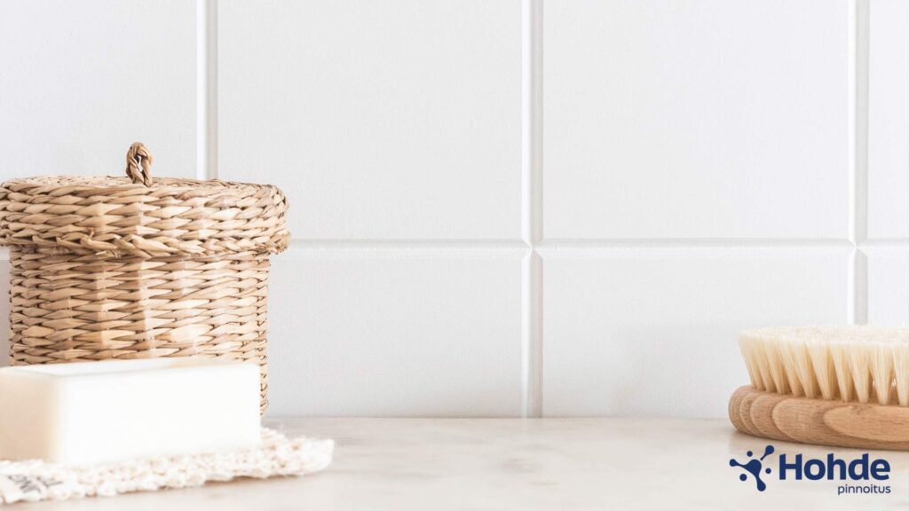 Valkoinen vessan laattaseinä, laattasaumat, saippua ja harja